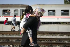 A refugee woman carries a child at a train station&nbsp;&hellip;