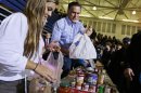 Republican presidential candidate, former Massachusetts Gov. Mitt Romney holds bags of food as he participates in a campaign event collecting supplies from residents local relief organizations for victims of superstorm Sandy, Tuesday, Oct. 30, 2012, at the James S. Trent Arena in Kettering, Ohio. (AP Photo/Charles Dharapak)