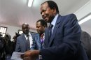 Cameroon's President Paul Biya holds a ballot paper before casting his vote at a polling centre in Yaounde