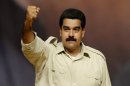 Venezuelan President Nicolas Maduro raises his clenched fist during a political meeting in Caracas, on August 7, 2013