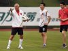 Coach Marcello Lippi gestures as Guangzhou Evergrande football club team member Qin Sheng stands next to him during a training session after a signing ceremony during a rainy day in Guangzhou