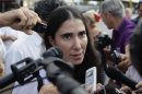 Cuba's best-known dissident, blogger Yoani Sanchez, speaks to reporters outside Havana's Jose Marti International Airport