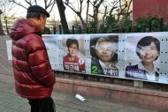 A man looks at posters of the candidates for South Korea's presidential election in Seoul, on December 19, 2012