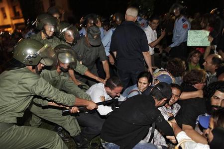 محتجون يشتبكون مع شرطة مكافحة الشغب خلال تظاهرة ضد العفو الملكي على مغتصب الاطفال الاسباني في الرباط يوم الجمعة - رويترز