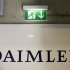 A emergency exit sign is pictured above a logo of German car manufacturer Daimler AG, before the annual news conference in Stuttgart