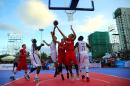 Players compete during a men's 3-on-3 basketball match between Qatar (white) and Vietnam, during the Asian Beach Games in Vietnam's central coastal city of Danang
