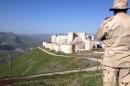A government soldier looks out over the renowned Crusader castle Krak des Chevaliers near the Syria-Lebanon border after forces loyal to President Bashar al-Assad seized the fortress on March 20, 2014