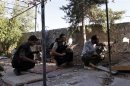 Free Syrian Army fighters take up positions with their weapons behind a wall in Aleppo's Sheikh Saeed neighbourhood