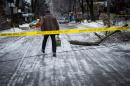 A man steps over downed power line near Dufferin Grove Park in Toronto on Sunday, Dec. 22, 2013 following an ice storm. (AP Photo/The Canadian Press, Ian Willms)