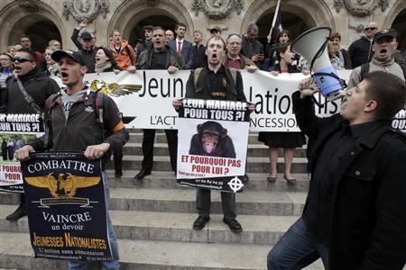 Members of the extreme right Nationalist Youth shout slogans on the steps of the Opera as they attend a protest march called, "La Manif pour Tous" (Demonstration for All) against France's legalisation of same-sex marriage, in Paris, May 26, 2013. Placards read, "Fight, Win, a right - Nationalist Youth" (L) and under the photo of a chimp, "Their Marriage for All ? And why not for Him ?" (C). REUTERS/Pascal Rossignol
