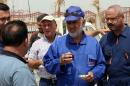 Iraqi Governor of the Maysan Province, Ali Dawai (C), chats with workers as he inspects a construction site on May 7, 2014 in the southeastern city of Amara