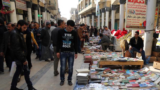 In this Friday, Jan. 23, 2015 photo, Iraqis look at books on al-Mutanabi Street, home to the city&#39;s book market in central Baghdad. One afternoon this month, Islamic State militants arrived at the Central Library of the northern city of Mosul in a non-combat mission. They broke the locks that kept the two-story building closed since the extremists overran the city in mid last year, loading some 2,000 books included children stories, poetry, philosophy, sports, health and cultural and scientific publications into six pickup trucks and leaving behind only the Islamic religious ones. (AP Photo/Karim Kadim)