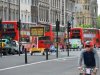 Buses pass by a sign advising that lanes will be reserved for Olympic transport in central London