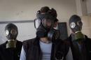 Volunteers wear gas masks during a class on how to respond to a chemical attack, in the northern Syrian city of Aleppo on September 15, 2013