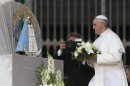 Pope Francis offers flowers to a statue of Our Lady of Lujan during his Wednesday general audience in St Peter's Square at the Vatican