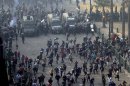 Protesters run from riot police during clashes at Tahrir square in Cairo