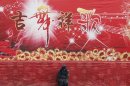 A security guard sits in front of a stage during the temple fair in Ditan Park, also known as the Temple of Earth, in Beijing