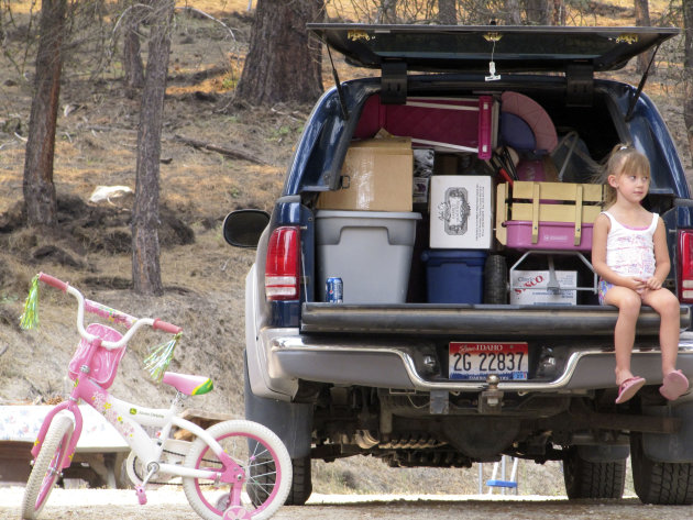 Lizzie Morris, 4, waits for her grandmother, Lorie Winmill, to load their belongings into a vehicle as they prepare to evacuate from their home in Featherville, Idaho on Wednesday, Aug. 15, 2012. They