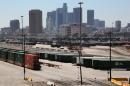 The Union Pacific Intermodal rail yard is viewed with the Los Angeles skyline on Friday, Aug. 28, 2015. The vast extension of land could be repurposed as the centerpiece of the proposed $1 billion residential village for the 2024 Olympic Games bid. But with a deadline to submit a U.S. candidate for the 2024 Games just 18 days away, the plan remains a mystery in many ways. The sprawling Olympic Village, to be built with mostly private funds, is tethered to a series of financial assumptions and question marks. (AP Photo/Richard Vogel)