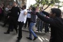 Christians scuffle with a police officer outside the Coptic Church in Cairo