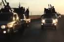 An image grab taken from a video released by the Islamic State group's official Al-Raqqa site via YouTube on September 23, 2014, allegedly shows recruits riding in armed trucks in an unknown location