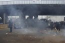 Police try to put out a fire set by opposition protesters during a political rally in Conakry