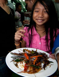 This undated photo provided by the United Nations Food and Agriculture Organization (FAO) shows a woman holding a plate with insects during an insect cuisine competition at an unknown location in Laos. The U.N. has new weapons to fight hunger, boost nutrition and reduce pollution, and they might be crawling or flying near you right now: edible insects. The Food and Agriculture Organization on Monday, May 13, 2013, hailed the likes of grasshoppers, ants and other members of the insect world as an underutilized food for people, livestock and pets. A 200-page report, released at a news conference at the U.N. agency's Rome headquarters, says 2 billion people worldwide already supplement their diets with insects, which are high in protein and minerals, and have environmental benefits. (AP Photo/Thomas Calame, FAO, ho)