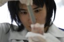A laboratory technician puts chopped fish into a plastic container while preparing it for cesium testing at Fukushima Agricultural Technology Centre in Koriyama, Fukushima prefecture
