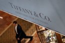 In this Tuesday, Nov. 27, 2012, photo a man walks under a banner displaying Tiffany & Co. in Boston. Tiffany & Co. said Thursday, Nov. 29, 2012, third-quarter net income fell 30 percent, stung by a higher-than-expected tax rate, ongoing economic weakness and high precious metal and diamond costs. (AP Photo/Elise Amendola)