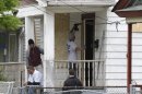 Workers board up the house Saturday, May 11, 2013 where three women were held in Cleveland on Saturday, May 11, 2013. Suspect Ariel Castro, who allegedly held three women captive for nearly a decade, is charged with rape and kidnapping. (AP Photo/Tony Dejak)