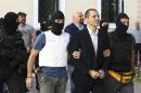 This photo taken on Tuesday, Oct. 1, 2013, shows lawmakers of the extreme far-right Golden Dawn party, Ilias Kasidiaris, center, Ilias Panayiotaros, center back, and Yannis Lagos, back left, are escorted by anti-terror police to a court for a preliminary hearing into charges of participating in a criminal organization in Athens. The specter of Neo-Nazism is no longer haunting Greece. It looks like it is here to stay. Even with its leader and most of its lawmakers behind bars, facing charges of participating in a 
