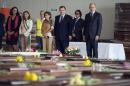 This picture released by the European Commission shows European Union President Jose Manuel Barroso (3rd R) and Italy's Prime Minister Enrico Letta (R) with officials standing near the bodies of the victims of a shipwreck October 9, 2013