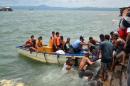 A body is carried by rescuers during a search and rescue operation following a ferry capsize in Ormoc city