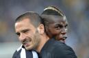 Juventus players Paul Pogba, right, and Leonardo Bonucci, left, celebrate at the end of a Serie A soccer match againsts Atalanta, at the Juventus stadium, in Turin, Italy, Monday, May 6, 2014. Juventus clinched its third straight and 30th overall Serie A title. (AP Photo/Massimo Pinca)