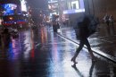 A commuter tries to hold onto her umbrella after being hit by a gust of wind in Times Square New York