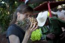 In this Dec. 8, 2012 photo, U.S. chef Kelsie Kerr smells a pineapple while shopping for fruit and vegetables at a farm in Havana, Cuba. Kerr traveled to Cuba with the California based "Planting Seeds" delegation that held give-and-take seminars with chefs and culinary students about slow food. Cuba has a longstanding culture of organic farming by necessity. During the "Special Period" of the 1990s, many private urban plots popped up in Havana amid austerity after the collapse of the Soviet Union. Unlike in the United States, pesticide-free is largely the rule here rather than the exception, mostly due to a lack of supply. (AP Photo/Ramon Espinosa)