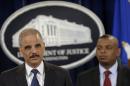 Attorney General Eric Holder, left, accompanied by Transportation Secretary Anthony Foxx, announces a $1.2 billion settlement with Toyota over its disclosure of safety problems, Wednesday, March 19, 2014, during a news conference at the Justice Department in Washington. (AP Photo/Susan Walsh)