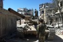 Soldiers loyal to the regime on a tank in a devastated street of the district of al-Khalidiyah, in Homs on July 30, 2013