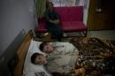 In this photo taken on Thursday, May 5, 2016, Abdul Rasheed, 9, front, and Shoaib Ahmed, 13, lie in a bed at a hospital in Islamabad, Pakistan. The boys are normal active children during the day. But once the sun goes down, they both lapse into a vegetative state — unable to move or talk. Dr. Javed Akram, told The Associated Press on Thursday that he had no idea what was causing the symptoms. (AP Photo/B.K. Bangash)