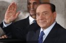 Italian former Premier Silvio Berlusconi waves to reporters as he leaves after attending a meeting with the People of Freedom party's lawmakers at the Lower Chamber in Rome, Friday, Aug. 2, 2013. Italy's former premier, Silvio Berlusconi, for the first time in decades of criminal prosecutions related to his media empire was definitively convicted of tax fraud and sentenced to prison by the nation's highest court, Judge Antonio Esposito, in reading the court's decision Thursday, declared Berlusconi's conviction and four-year prison term "irrevocable." He also ordered another court to review the length of a ban on public office ó the most incendiary element of the conviction because it threatens to interrupt, if not end, Berlusconi's political career. (AP Photo/Riccardo De Luca)