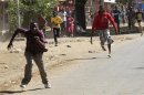 An ethnic Somali man chases a man from a rival group with a machete during the second day of skirmishes in the Eastleigh neighbourhood of Kenya's capital Nairobi