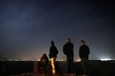 Residents of the southern Israeli town of Sderot watch cross-border fighting from a hill overlooking the northern Gaza Strip, before a ceasefire