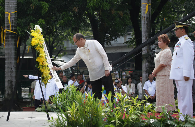 Philippine President Benigno Aquino III, left, arranges a wreath during ceremonies marking the 115th Philippine Independence Day at Liwasang Bonifacio, a square named after Filipino revolutionary leader Andres Bonifacio a in Manila, Philippines on Wednesday June 12, 2013. Aquino vowed Wednesday his country will not back down from any challenge to its sovereignty and territory amid a sea dispute with China. (AP Photo/Aaron Favila)