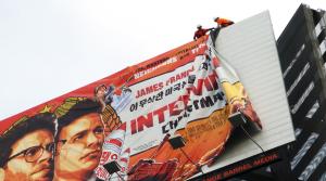 Workers remove the poster for &quot;The Interview&quot; &hellip;