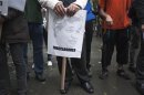 A protester in the Occupy Wall Street movement holds a sign with the face of JPMorgan CEO Jamie Dimon as he participates in a rally in New York