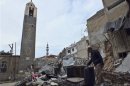 A man inspects rubble and trash in Al-Hamidiya neighbourhood in Homs