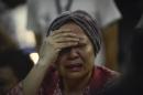 A woman reacts after hearing about the Malaysia Airlines passenger plane crashing in eastern Ukraine at Kuala Lumpur International Airport in Sepang, Malaysia, Friday, July 18, 2014. Malaysia Airlines said it lost contact with Flight 17 over Ukrainian airspace Thursday. It was flying from Amsterdam to Kuala Lumpur, Malaysia. (AP Photo/Joshua Paul)