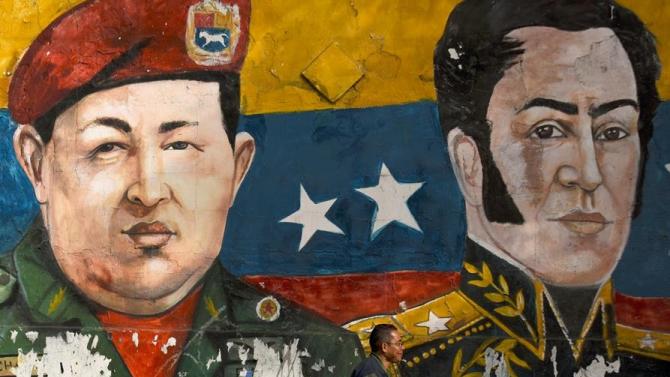 A mural of late Venezuelan president Hugo Chavez (left) and XIX century hero Simon Bolivar on a wall in the low-income Petare neighborhood