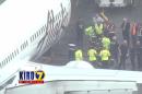In this frame from video, workers walk with a Menzies Aviation cargo worker after the worker was removed from the cargo hold of an Alaska Airlines passenger airplane, Monday, April 13, 2015, at Seattle-Tacoma International Airport, in Seattle. The Los Angeles-bound flight had to return to Seattle when noises were heard from the worker in the hold as the plane took flight. (KIRO 7 via AP) MANDATORY CREDIT; LOCAL TV OUT