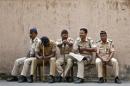 A policeman yawns as he sits with his colleagues outside a court where the case of the gang-rape of a photojournalist was heard in Mumbai